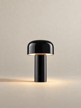 Portable dome lamp in Glossy Black, light on, warm neutral studio